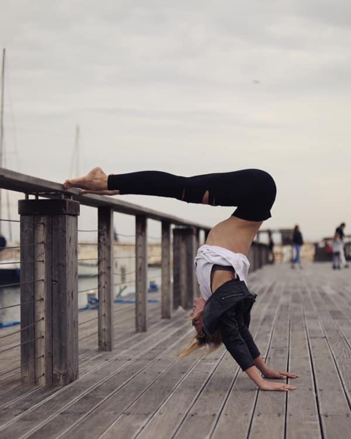 Lola practicing a handstand on a pier