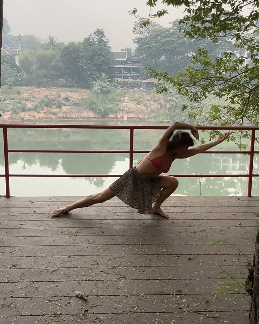 Lola integrating Dragon Wings movement in a low lunge beside the river