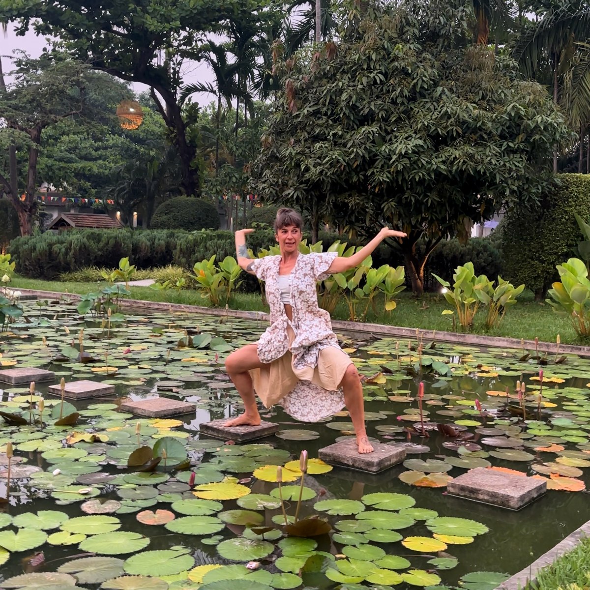 Lola expressing fluid Dragon Wings movement beside a lotus pond