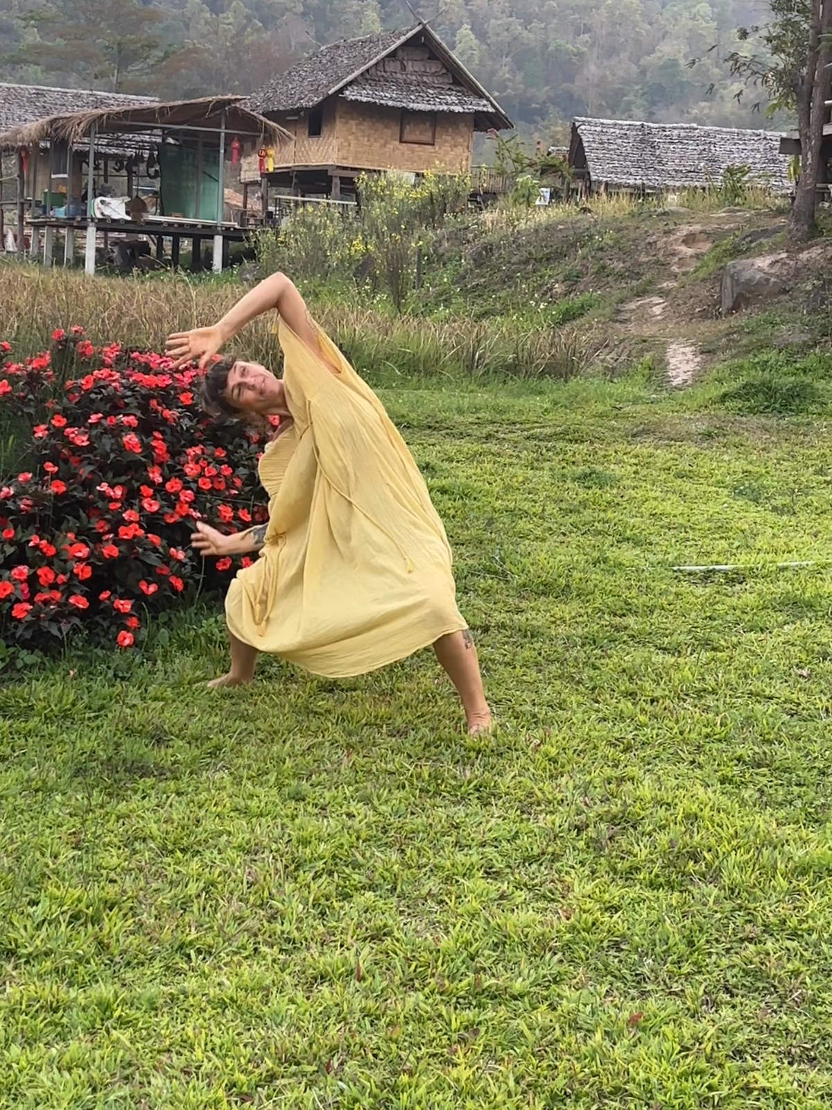 Lola extending through a wing-like movement in a yellow dress